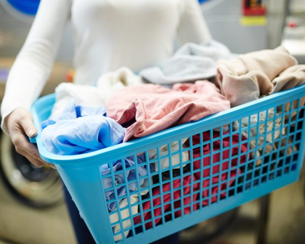 Basket with dirty clothes held by laundress